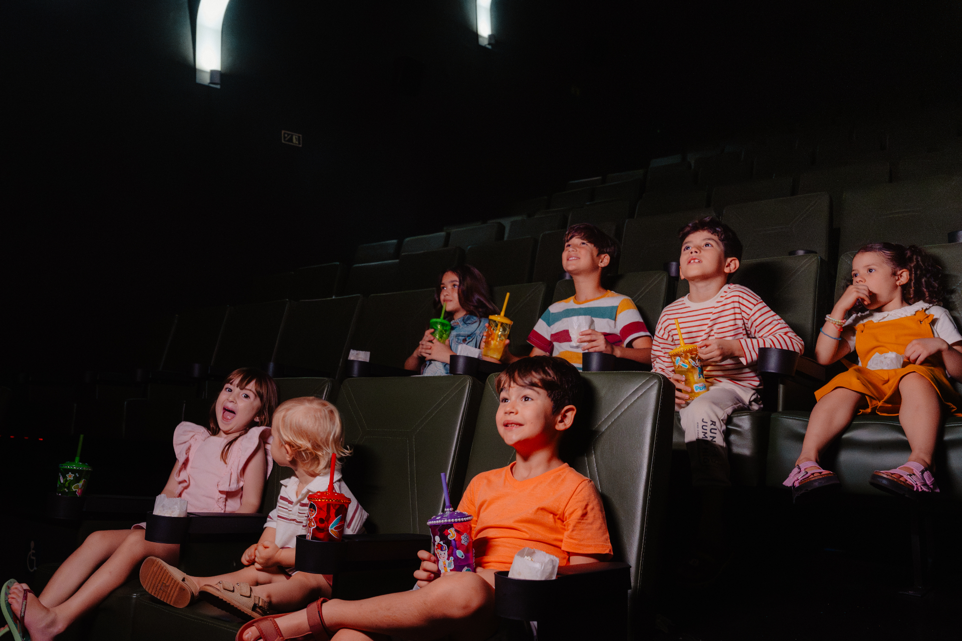 Crianças assistindo filme no cinema do resort Tauá